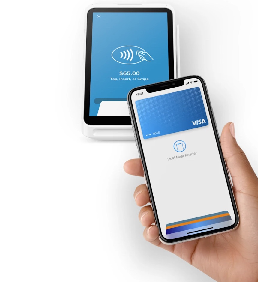 A customer taps their phone on a Square terminal to pay $65.00
